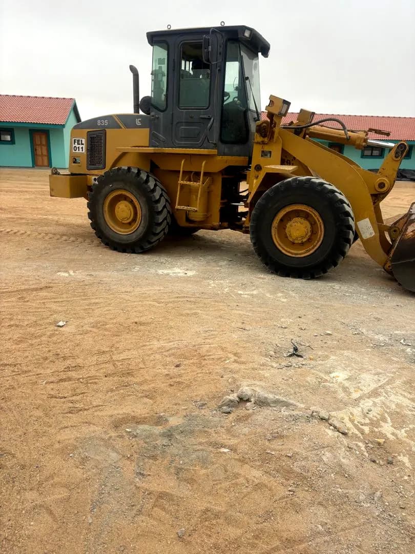Front-end loader levelling sand on a work site