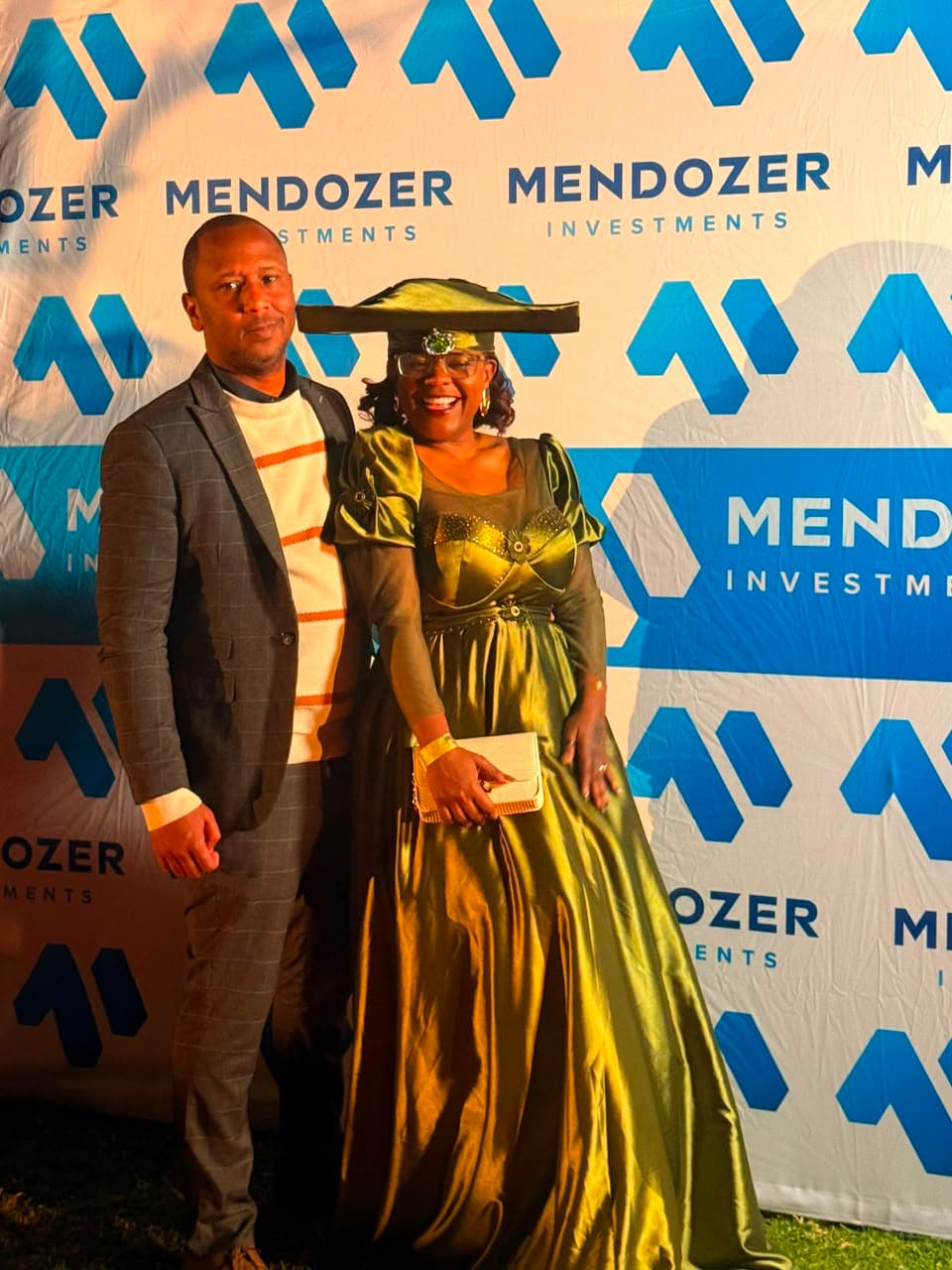 Attendees in front of a Mendozer-branded event backdrop