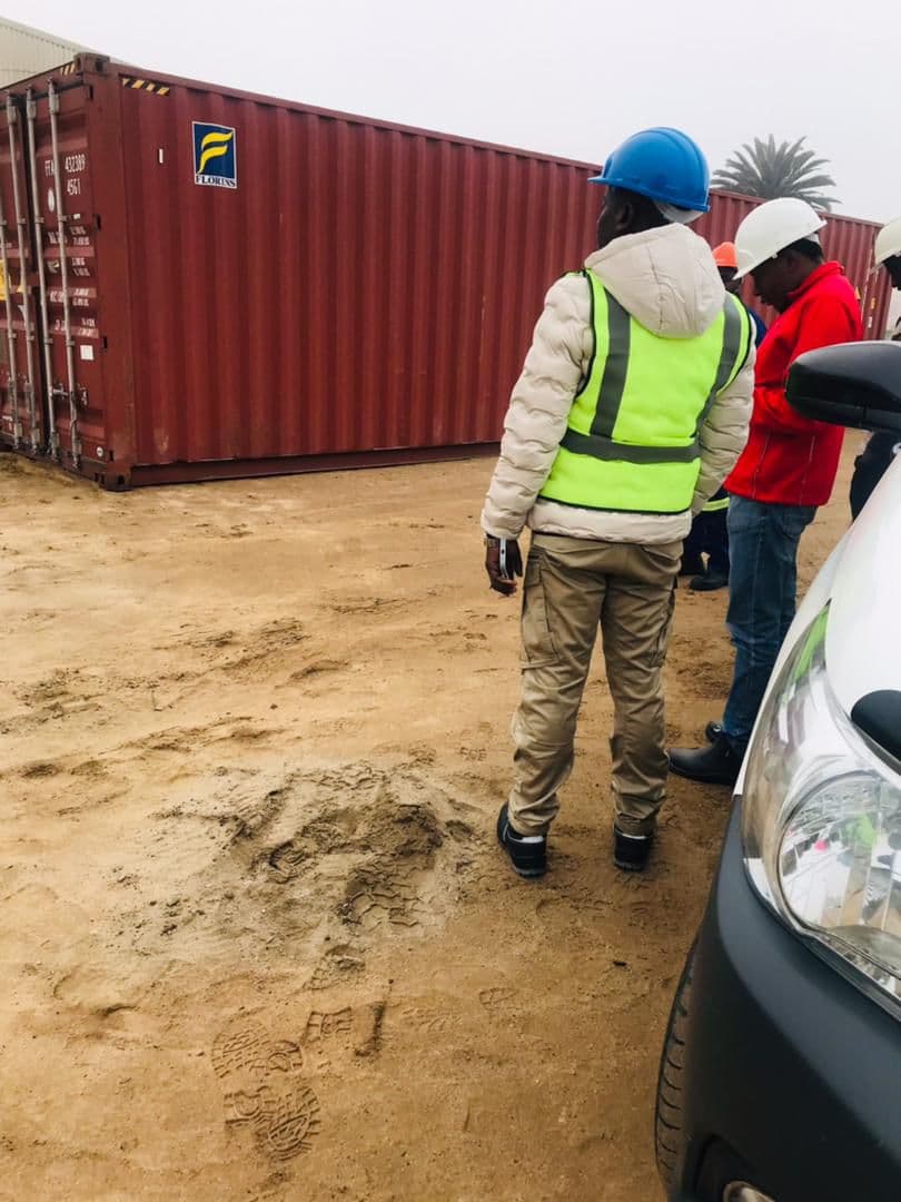 People beside a container at a work site